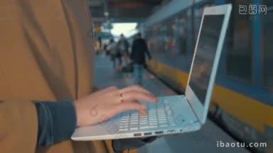 <strong>一个</strong>女人站在站台上用笔记本电脑打字的特写镜头